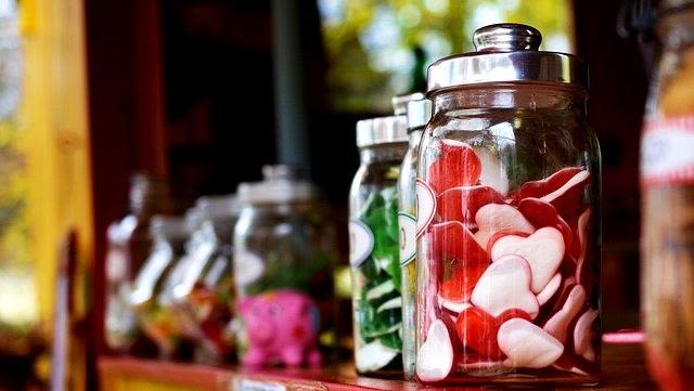 Jars of sweets, with red, heart-shaped candies in the foreground