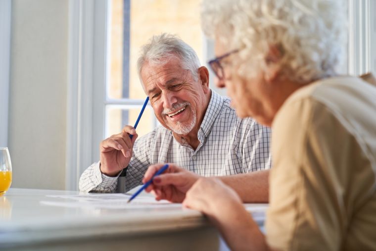 Mature couple sitting doing a crossword